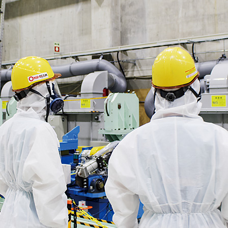 作業員がタンク除染・解体設備を確認している様子